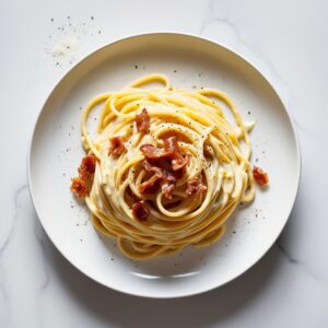 Talerz spaghetti carbonara z aksamitnym kremowym sosem jajeczno serowym chrupiacym guanciale i posypany swiezo mielonym pieprzem na eleganckim bialym tle. 1 Talerz spaghetti carbonara z aksamitnym kremowym sosem jajeczno serowym chrupiacym guanciale i posypany swiezo mielonym pieprzem na eleganckim bialym tle. 1