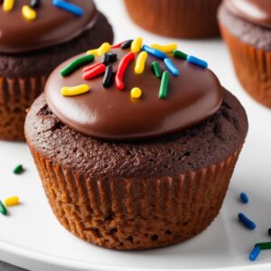 Zblizenie na puszysta teksture muffinki czekoladowej wierzch pokryty gladka czekolada i ozdobiony posypkami w olimpijskich kolorach. Zblizenie na puszysta teksture muffinki czekoladowej wierzch pokryty gladka czekolada i ozdobiony posypkami w olimpijskich kolorach.